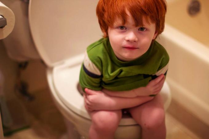 Liten gutt som sitter på toalettet