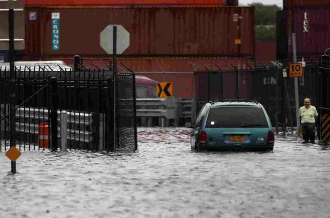 En person går gjennom en oversvømmet gate etter orkanen Irene 28. august 2011 i Red Hook-området i Brooklyn bydel i New York City.