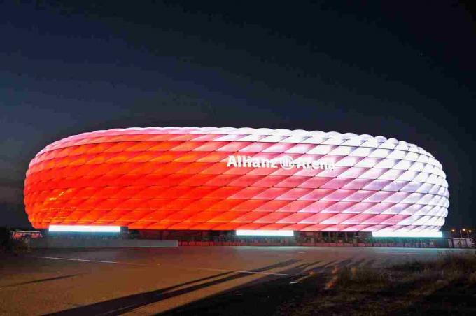 hvitt om dagen, skulpterte utsiden av Allianz Arena lyser rødt om natten