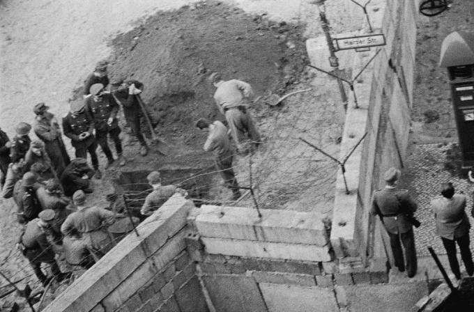 Gruppe østtyske soldater undersøker en tunnel gravd under Berlinmuren.