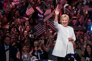 Hillary Clinton bølger foran mengden av folk som vifter med amerikanske flagg