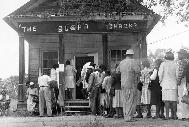 Afroamerikanske velgere, i stand til å stemme for første gang i landlige Wilcox County, Alabama, stiller seg opp foran et valglokale etter vedtakelsen av den føderale stemmerettsloven i 1965.