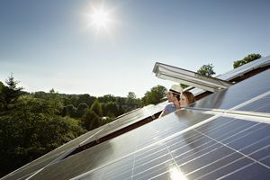 Par som kikker ut av taket på solcellepanelet