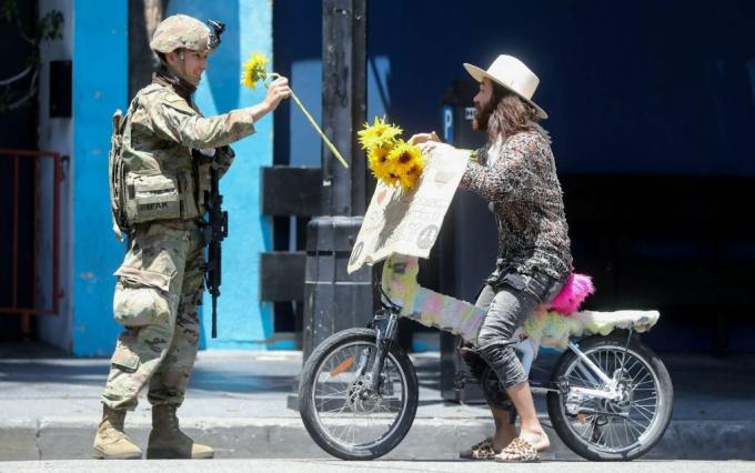 En nasjonalgardsoldat mottar en blomst fra en demonstrant under en fredelig demonstrasjon over George Floyds død i Hollywood 3. juni 2020.