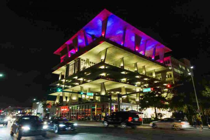 natt utsikt over parkeringshus på flere nivåer, opplyst med lilla lys i toppetasjen