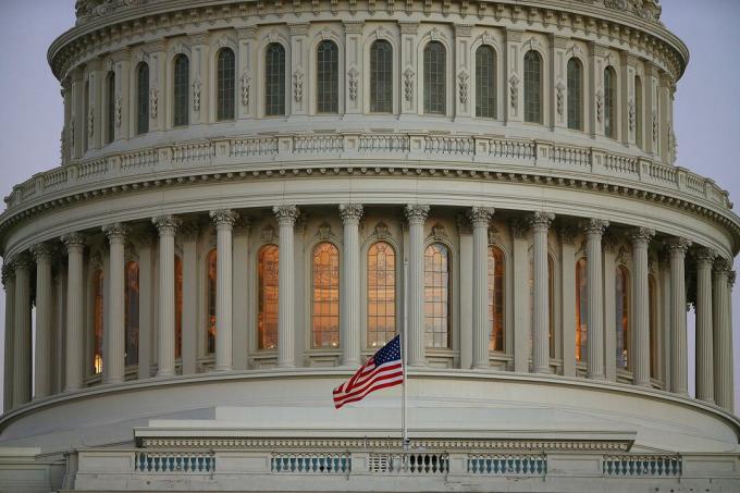 Nærbilde av den amerikanske Capitol-kuppelen med flagg på halv stab