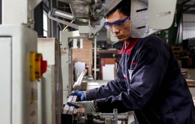 En ansatt som jobber med aluminiumsprodukter på en fabrikk i Zouping i Kinas østlige Shandong-provins