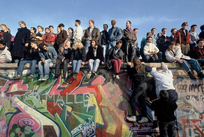 Folk klatrer opp på Berlinmuren 10. november 1989 for å feire.