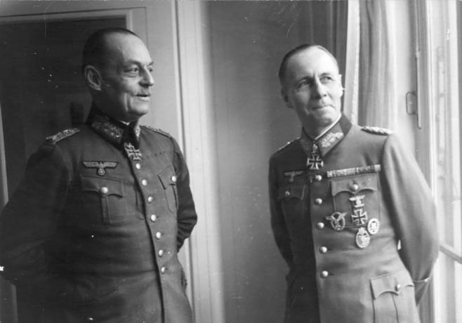 Gerd von Rundstedt og Erwin Rommel i tyske militæruniformer som sto nær et vindu.