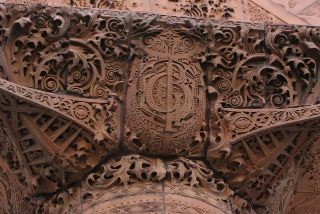 brunskulptert terra cotta-detalj, utsmykkede krøller og monogram GB