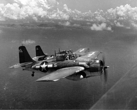 To FM-2 Wildcat-jagerfly i flukt over vann.