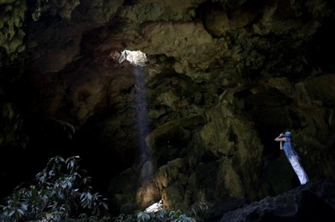 En turist tar bilder ved inngangen til Calcehtok-hulen i Oxkintok, delstaten Yucatan på Mexicos Yucatan-halvøy.