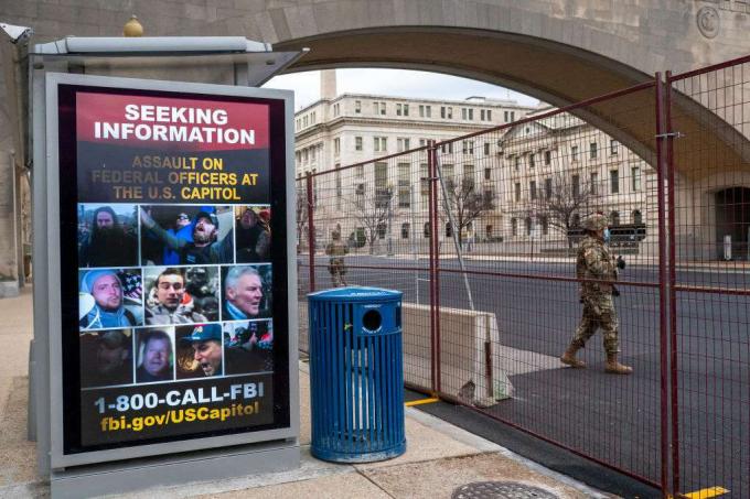 En nasjonal garde går forbi en plakat som søker informasjon om det amerikanske Capitol-angrepet 19. januar 2021.
