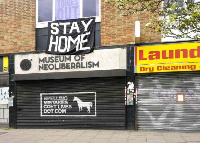 Stort STAY HOME-skilt over stengt Museum of Neoliberalism i Lewsiham, London, England.