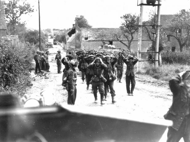 Tyske soldater marsjerte nedover en gate med hendene på hodet i overgivelse.
